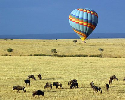 Hot air balloon drifting over the Serengeti plains at sunrise